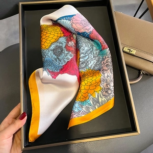 Carré en soie vintage à fleurs avec bords roulés orange sur plateau de luxe