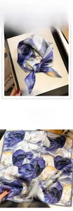 Detailed macro view of purple floral print on premium silk scarf with fine edge stitching