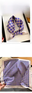 Detailed view of silk square scarf featuring retro geometric patterns and satin luster