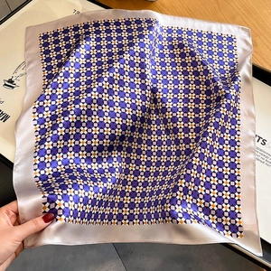 Elegant silk scarf featuring purple geometric grid pattern on a stylish magazine backdrop