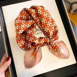 Elegant geometric silk scarf with orange and champagne gold pattern in a gift box