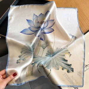 Elegant mulberry silk square scarf with blue hand-painted lotus pattern on wooden desk