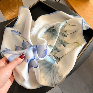Silk square scarf featuring light blue lotus print and elegant rolled edges for women