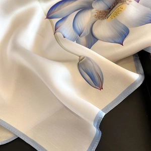 Elegant mulberry silk square scarf featuring blue lotus floral patterns on white silk