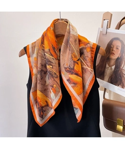 Close-up of lightweight satin square scarf with orange floral print draped on a hanger