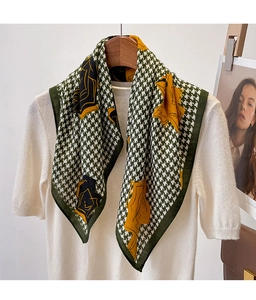 Detail of green and white houndstooth scarf with yellow floral print and hemmed edges