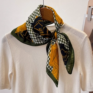 Detailed view of houndstooth silk scarf with yellow and green abstract floral patterns