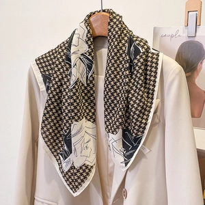 Detailed close-up of houndstooth floral scarf styled on a chic beige blazer lapel