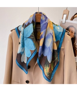 Detailed texture of cotton-linen floral scarf draped over a khaki trench coat