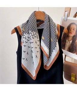 Detail of printed square scarf with horse pattern on hanger with vintage bag