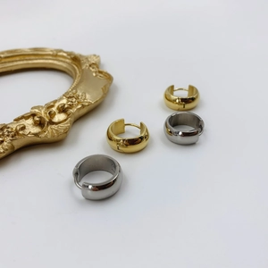 Detail of gold and silver chunky round hoop earrings on a vintage frame background