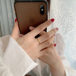 Detail of gold geometric ring featuring sharp triangular patterns and polished finish