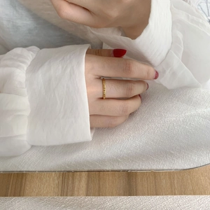 Minimalist gold-plated geometric ring with pyramid texture on model's hand