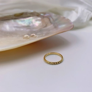 Minimalist gold geometric square pointed ring with rivet texture in a seashell