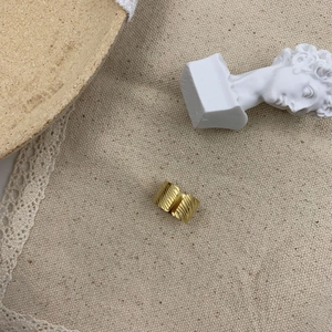 Detailed view of wide 18K gold plated steel ring with geometric textured surface