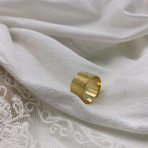Macro detail of 18K gold-plated wide ring with unique brushed diagonal texture finish