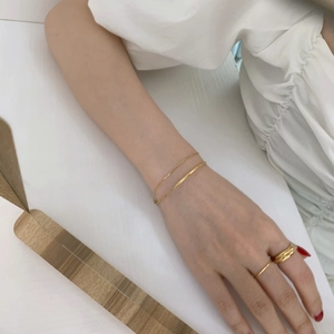 Minimalist 18K gold plated layered chain bracelet and ring set for women on model wrist