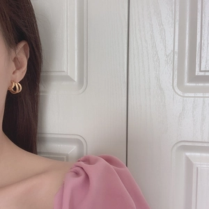 French minimalist gold irregular geometric triple hoop earrings worn by a female model