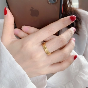 Detail of wide gold textured multi-layer ring featuring a polished metallic finish