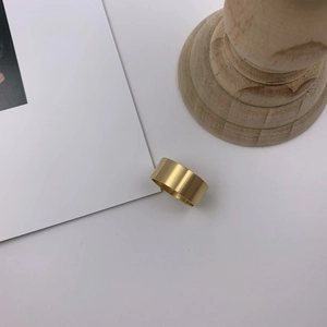 Minimalist wide gold band ring with a brushed matte finish shown on a clean white background