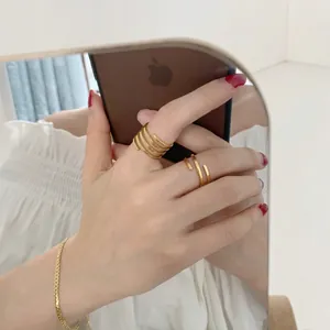 Chic multi-layer spiral open ring in gold finish worn as a stylish index finger ring
