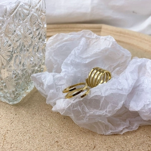 Detail view of gold multi-layer spiral ring and double-layered minimalist open ring set