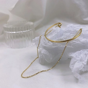 Detailed macro shot of 18K gold plated minimalist chain bracelet on a textured background
