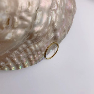 Minimalist 18K gold plated textured slim ring displayed on a natural seashell