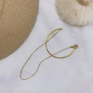 Detail view of 18K gold plated minimalist chain bracelet with arched bar and spring clasp