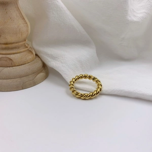 Detailed close-up of a gold-plated twisted rope ring with elegant metallic spiral texture