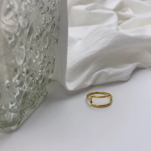 Minimalist gold hollow oval geometric ring made of stainless steel on white background