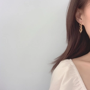 Minimalist gold chain earrings in polished alloy shown on a model with white square neck top