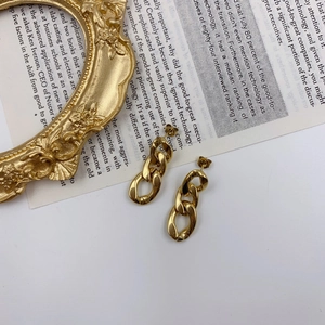 Detailed macro view of gold chain link earrings on vintage book background