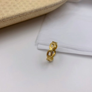 Gros plan détaillé d'une bague chaîne ajourée minimaliste en or brillant sur fond blanc