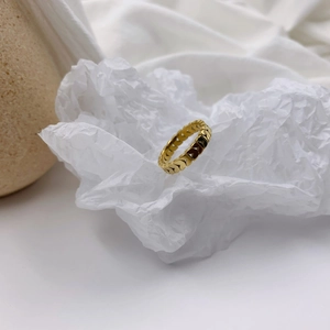Detailed view of hollow heart pattern gold ring on minimalist stone background