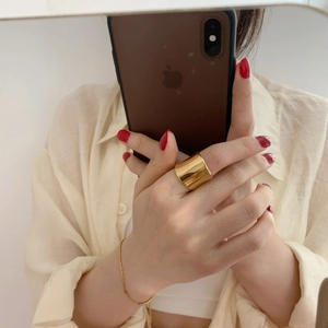 Close-up of wide gold irregular ring featuring a minimalist concave polished mirror design