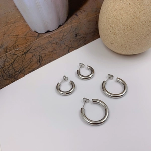 Minimalist silver C-shaped hoop earrings in two sizes with polished metallic finish