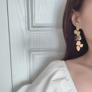 Close-up of elegant matte gold layered petal drop earrings on a female model