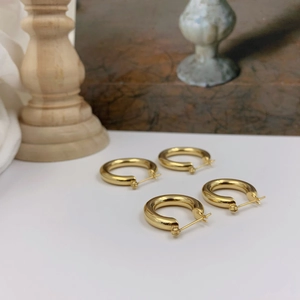Set of two pairs of minimalist gold hollow hoop earrings with a polished metallic finish