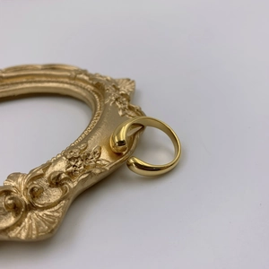 Gros plan détaillé d'une bague ouverte goutte d'eau dorée sur un cadre vintage