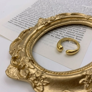 Vue détaillée d'une bague dorée minimaliste sur cadre vintage et papier écrit