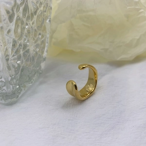 Detailed close-up of shiny gold irregular open ring with a polished minimalist finish