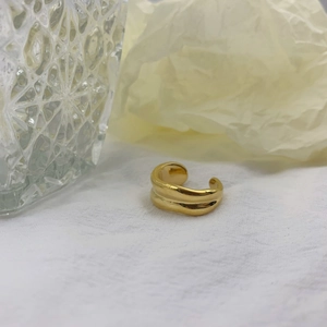 Detailed macro view of the irregular golden wave texture on the polished open ring