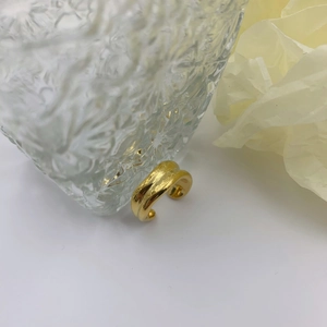 Irregular golden open ring featuring artistic lava texture and a minimalist polished finish