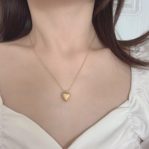Elegant gold heart pendant necklace for women worn on neck with snake chain detail
