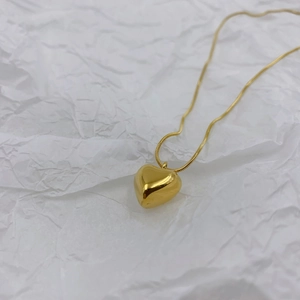 Elegant gold heart pendant necklace featuring a polished mirror finish snake chain