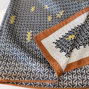 Elegant geometric patterned silk scarf in navy and yellow with twill texture