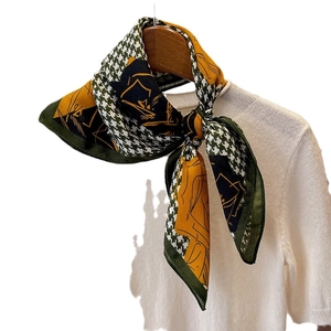 Houndstooth and floral silk-style scarf tied on a white knit shirt for women