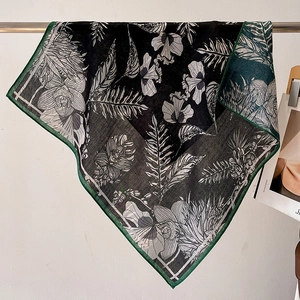Élégant foulard en soie à fleurs avec bordures vertes suspendu sur métal