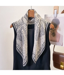 Detail of elegant silk square scarf with Greek Key border styled on black clothing